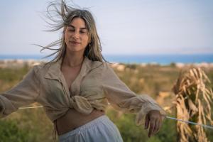 une femme tenant une corde dans un champ dans l'établissement Aetheria & Aura Suites by Temma Villas, à Chersónissos