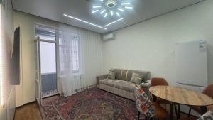 a living room with a couch and a table at Landmark in Astana +3 photos