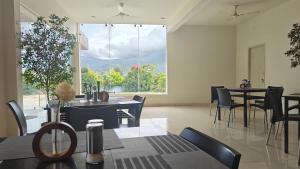 a dining room with tables and chairs and a large window at Golden Hill Resort in Chikmagalūr