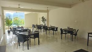 a restaurant with tables and chairs in a room at Golden Hill Resort in Chikmagalūr