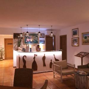 a hotel room with a bed, table, chairs and a painting on the at Hotel Pop in Cala Gonone
