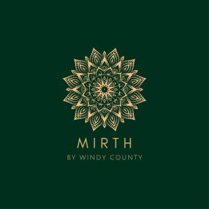 a gold mandala logo on a green background at Mirth by Windy County in Vagamon