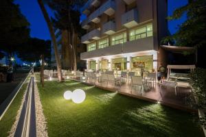 an apple sign on the grass in front of a building at Hotel Condor in Milano Marittima
