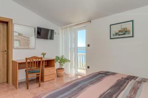 Un dormitorio con una cama y un escritorio y una ventana. en Heavenly Dream House With Pool, en Stanići