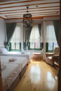 Un dormitorio con dos camas y un sofá y ventanas. en 3 Floor History Mansion, en Estambul