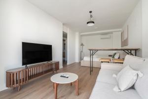 a living room with a couch and a tv and a bed at Business Suite con Garaje y Piscina Climatizada ALQUILER TEMPORAL in San Sebastián de los Reyes