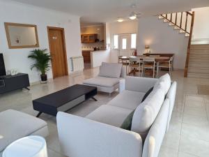 a living room with white furniture and a dining room at Villa Flavia in Aljezur
