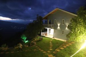 a house at night with a person walking in the yard at The Blissful Trails 3BR Home 2 in Satkhol by Homeyhuts in Mukteswar