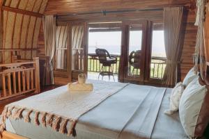 a bedroom with a bed with a view of the ocean at Lembongan Hilltop Retreat Villa in Nusa Lembongan +14 photos
