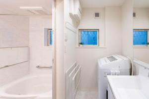 a white bathroom with a tub and a sink at 夢の宿 東中野 134t in Tokyo +52 photos