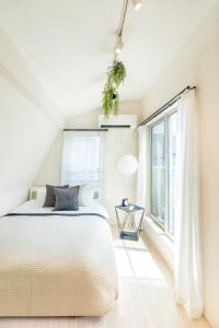 a white bedroom with a bed and a window at 夢の宿 東中野 134t in Tokyo