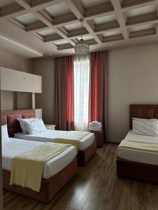 a hotel room with two beds and a window at Hotel Veliera in Durrës