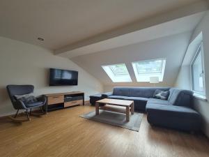 a living room with a blue couch and a chair at Appartements MAYR inklusive ganzjährig GRATIS Zugang zur ALPENTHERME und im SOMMER kostenlose Bergbahnnutzung in Bad Hofgastein