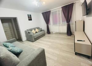 a living room with a couch and a refrigerator at DACAFI Luxury Apartment in Hunedoara