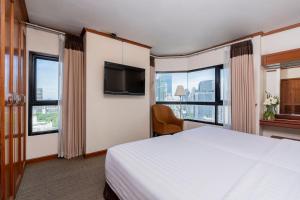 a hotel room with a bed and a flat screen tv at Grand Diamond Suites Hotel in Bangkok +52 photos