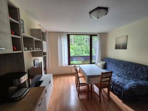 a living room with a table and a blue couch at Elit Pamporovo Accommodation in Pamporovo