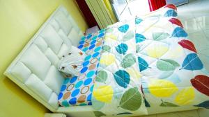 a room with a bed with a quilt on it at Prestige Villa Palace in Kigali