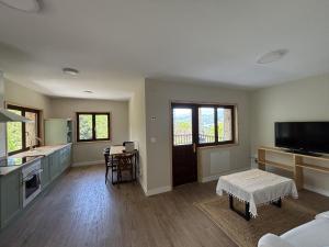 ein Wohnzimmer mit einer Küche mit einem Tisch in der Unterkunft Casa Rural Raiz y Cumbre in Con