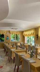 a restaurant with wooden tables and chairs and windows at Hotel Poker in Misano Adriatico