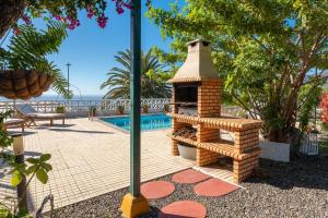 a brick fireplace next to a swimming pool at Casa Aloe in El Paso