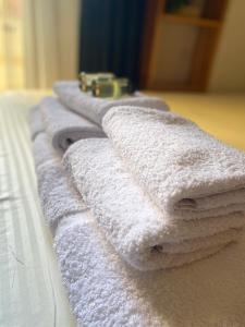 - une rangée de serviettes blanches sur un lit dans l'établissement Studio Astir, à Tirane 17 autres photos