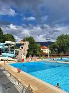 a large swimming pool with people in the water at Merano appartamento in Merano