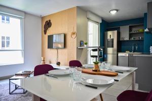 a kitchen with a white table and purple chairs at Le Golden - Centre Ville - Accès Transports en Commun - Balcon Cosy - Commerces à Proximité in Schiltigheim
