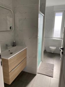 a white bathroom with a sink and a toilet at Le Stade Metz 1 Wifi Un Séjour à Part in Longeville-lès-Metz +66 photos