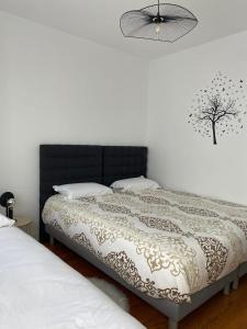 a bedroom with a bed with a black headboard at Le Stade Metz 1 Wifi Un Séjour à Part in Longeville-lès-Metz