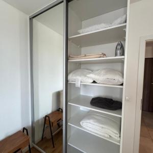 Un armario con estantes blancos y una puerta de cristal. en Lubelska SkyRes City View & Free Parking, en Rzeszów