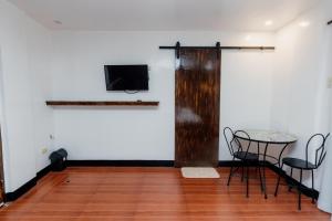 une pièce avec une table et des chaises et une télévision sur un mur dans l'établissement Villa Gertrudes Beach Resort, à Surigao