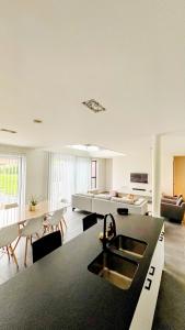 a kitchen and living room with a sink and a couch at Bruggeske aan't bos in Mol +18 photos
