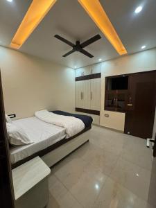 a bedroom with a bed and a ceiling fan at Hridayam Kashi Homestay- Maldahiya in Varanasi