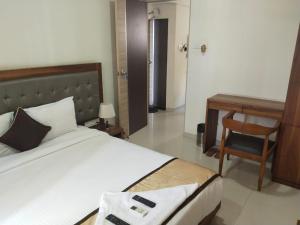 a bedroom with a bed and a desk and a chair at Shiv-Om in Jāmb