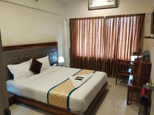 a bedroom with a large bed and a desk at Shiv-Om in Jāmb