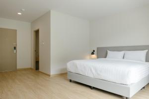 a bedroom with a large white bed with white sheets at M Hotel Kanchanaburi in Ban Chuk Kum +26 photos