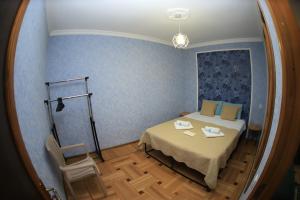 a small room with a bed and a mirror at Jacquard Apartment in the centre of Kutaisi in Kutaisi