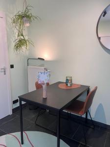 a table with two chairs and a vase with flowers on it at Au Petit Pont de Champagne in Waimes
