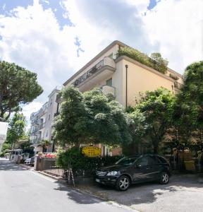 Residence Villa Ofelia في ريميني: سيارة سوداء متوقفة أمام مبنى
