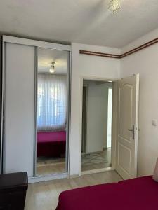 a bedroom with a mirror and a room with a bed at Apartman Mina in Prijepolje +7 photos