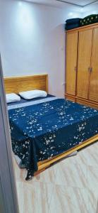 ein Schlafzimmer mit einem Bett mit einer blauen Tagesdecke mit goldenen Flecken in der Unterkunft Saidia Residence in Saidia 