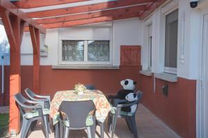 a panda bear sitting at a table on a patio at Tiszafa Vendégház Nagykanizsa in Nagykanizsa