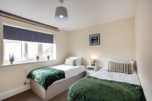 a bedroom with two beds and a window at Boyton House Sleeps 14 Long Stays Parking Wi-Fi in Swindon