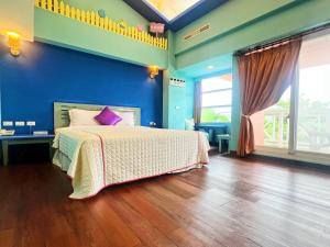 a bedroom with a bed and a blue wall at 墾丁茉莉民宿 in Kenting