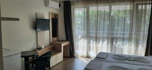 a bedroom with a bed and a large window at Алюр студио Приморско - Studio Allure Primorsko in Primorsko