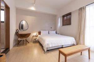 Un dormitorio con una cama, una mesa y un espejo. en Lunar Haven, en Magong