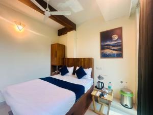 a bedroom with a bed with a white and blue at Rio Rooms Calicut Near Mims Hospital in Kozhikode