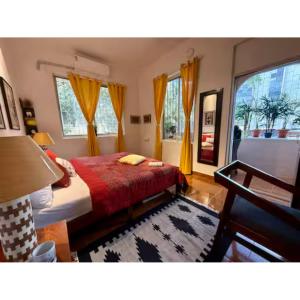 Schlafzimmer mit einem Bett mit einer roten Decke und Fenstern in der Unterkunft African Sojourn 1 bed 2 bath Spacious Prkg Dominos 2 in Jāmb