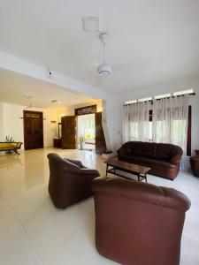 a living room with two couches and a table at Villa bodhi Ahangama, Home stay in Ahangama