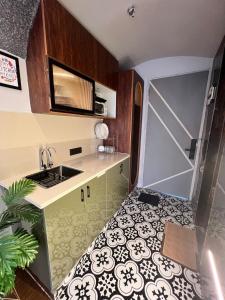 a kitchen with a sink and a counter with a door at Project Artisan's Retreat! in Ghaziabad